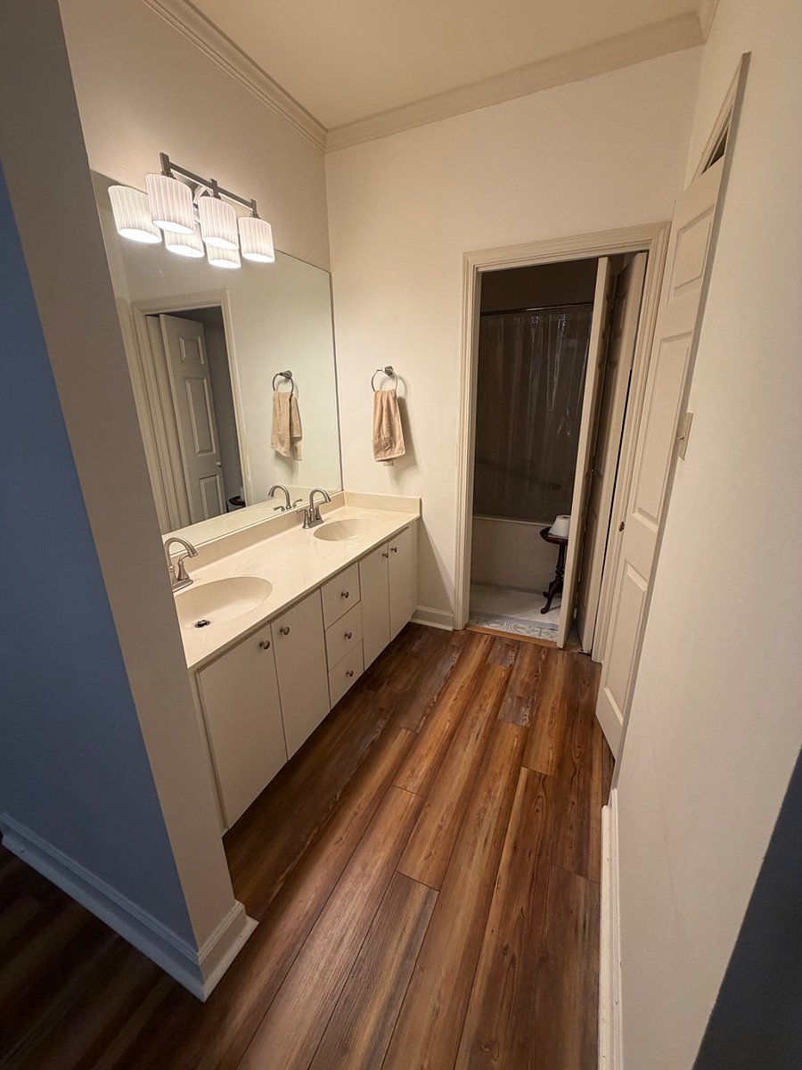 Downstairs vanity and bath with large walk in closet on right.    New tile floors and paint. 