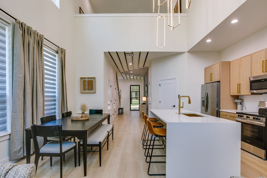 Open dining and kitchen with island and stools.