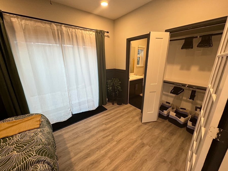 Ground floor bedroom closet with hangers and sliding door access to back patio