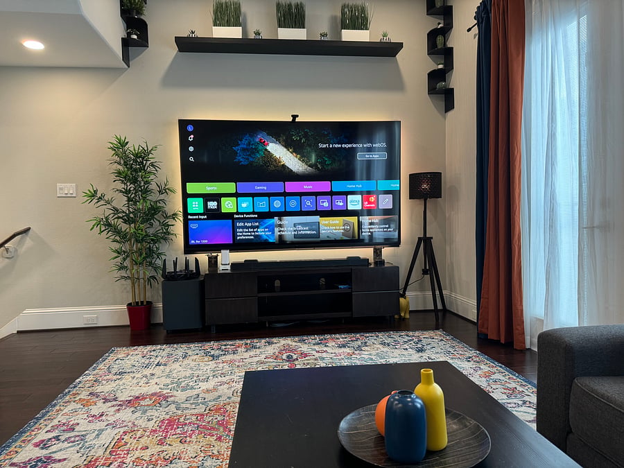 Living room view of immersive home entertainment system (97" TV with backlight, automatically detected JBL Dolby Atmos surround sound), super-fast ASUS ROG gaming router