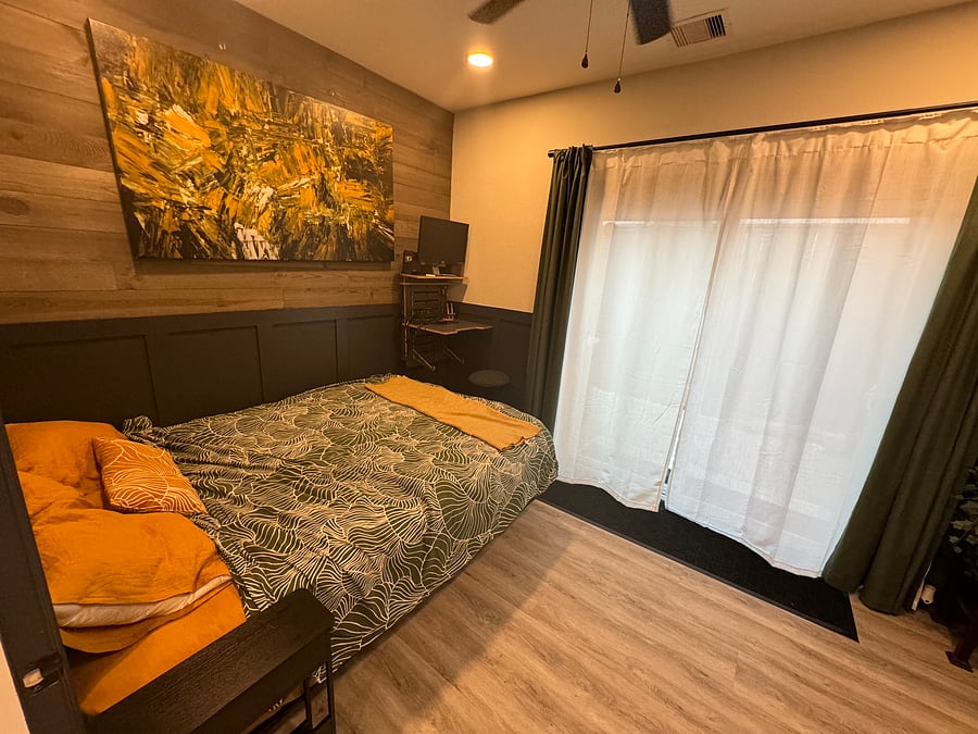 Ground floor bedroom with queen sized bed (with sliding drawer containing extra bedding), sit/stand workstation