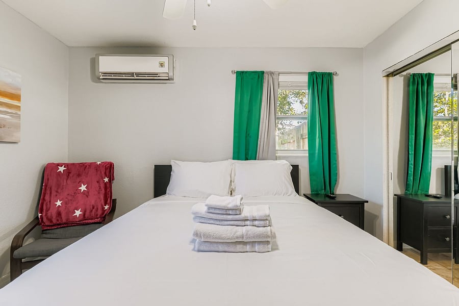 Master bedroom with queen bed, easy chair and ottoman