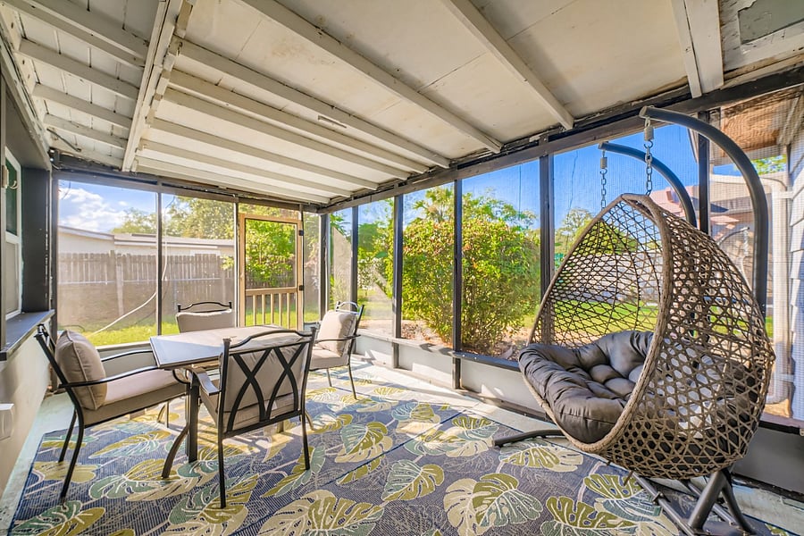 Screened lanai with table and chairs.