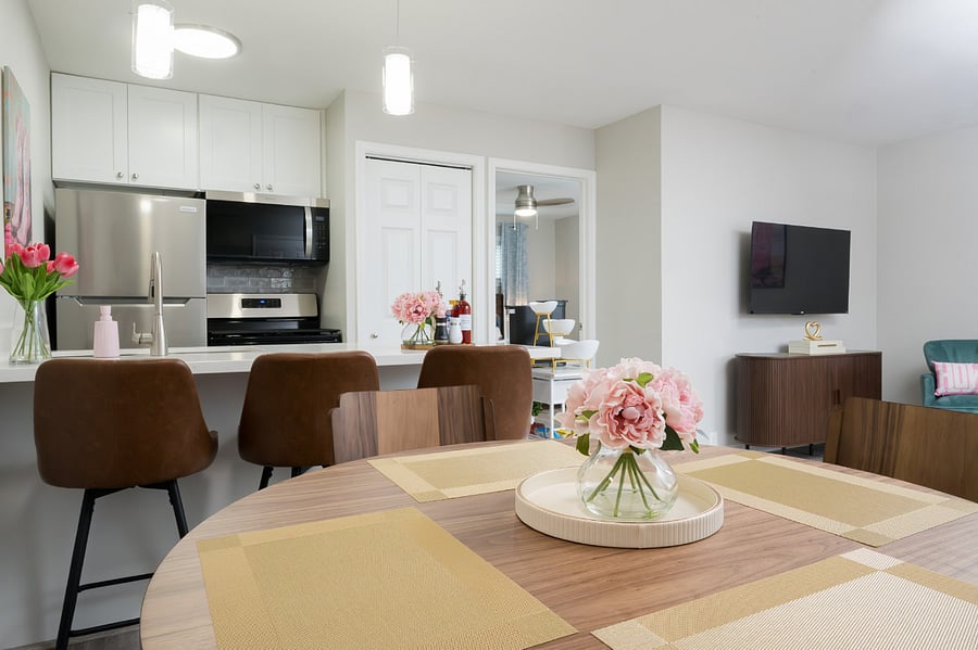 Enjoy your meals set within a bright, open space that connects seamlessly to a modern kitchen and a cozy lounge area.