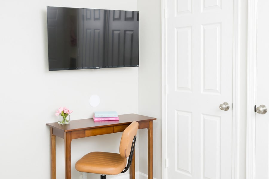 A dedicated workspace featuring a classic wooden desk and a comfortable leather swivel chair.
