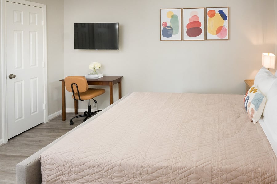 This versatile guest room features a dedicated workspace with a sleek wooden desk, perfectly positioned for remote work or study.