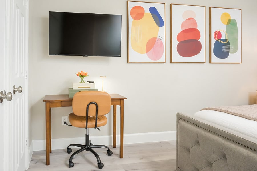 Dedicated workspace with a mid-century desk, ergonomic chair, and vibrant abstract art.