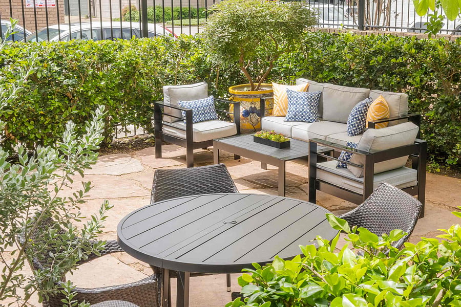 Private stone patio with a cozy lounge area and a stylish outdoor dining set.