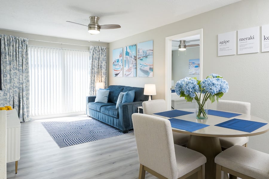Enjoy a seamless open-concept design where a charming dining set meets a cozy living area.