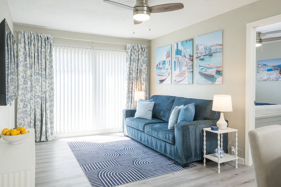 Unwind in a serene, coastal-inspired living area featuring a plush blue sofa and elegant decor.