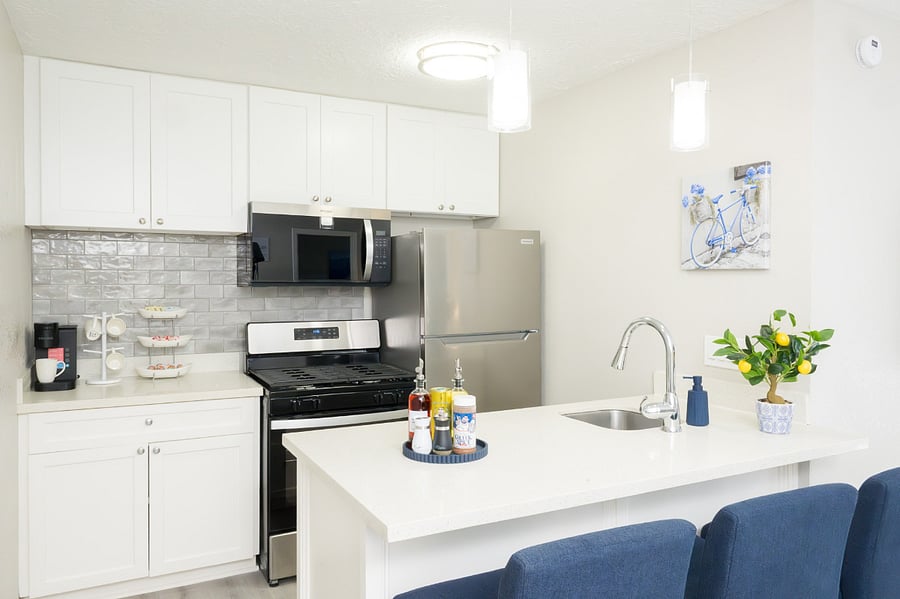 Cook with ease in this bright, contemporary kitchen with sleek stainless steel appliances and white cabinetry