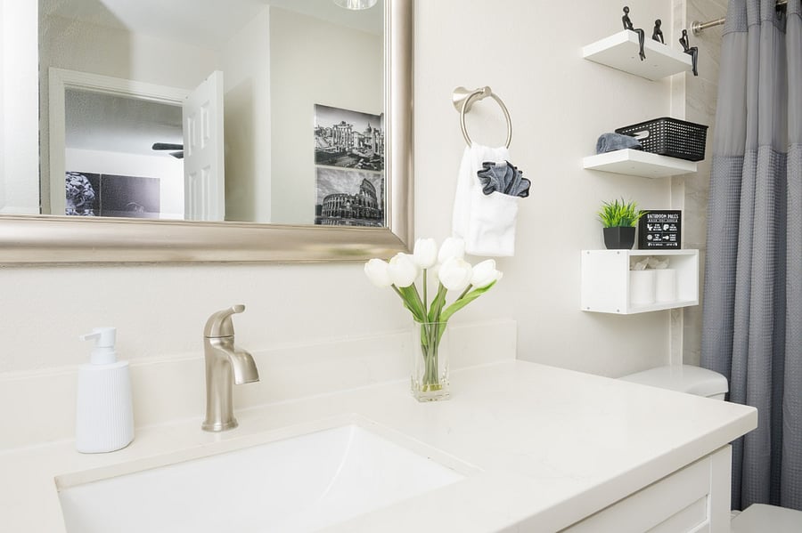 Contemporary bathroom featuring a clean white vanity, sophisticated gray accents, and thoughtful amenities.