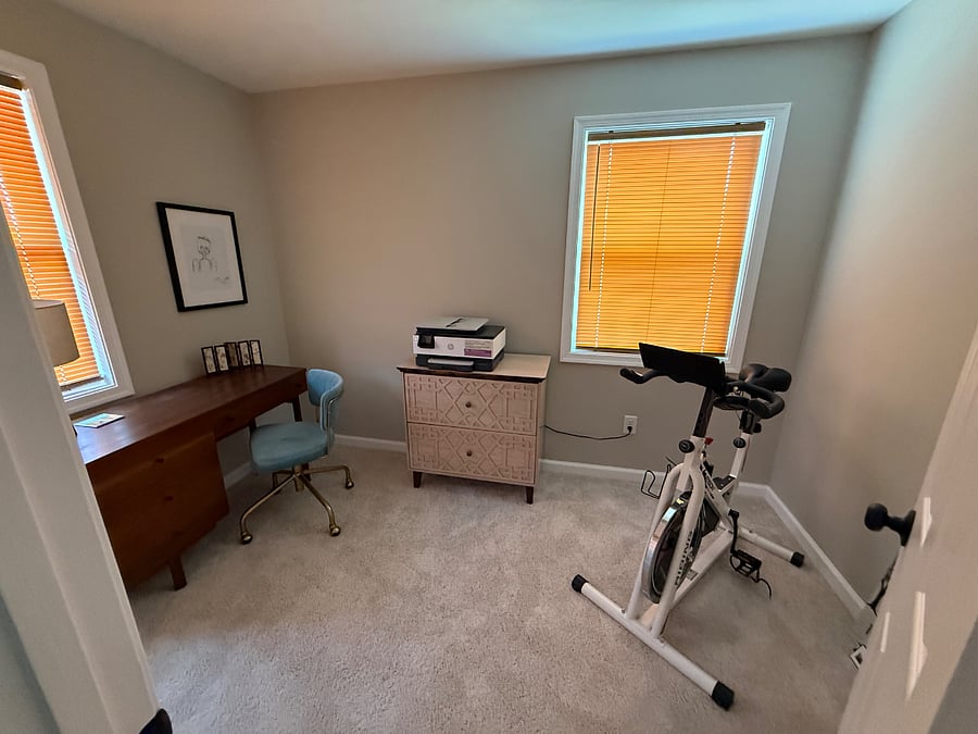 Small office with printer and an exercise bike 