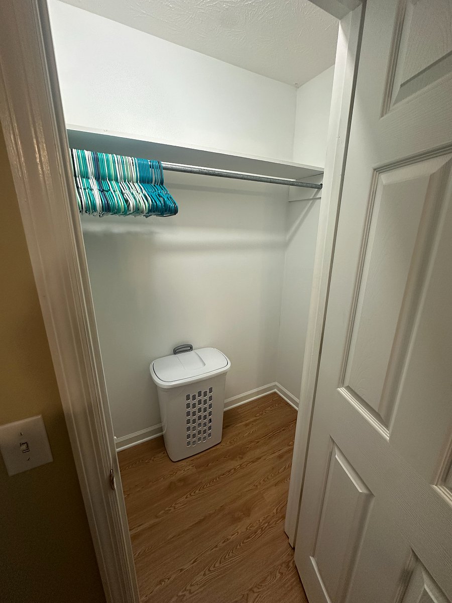 Large, private closet space with hangers and a hamper.