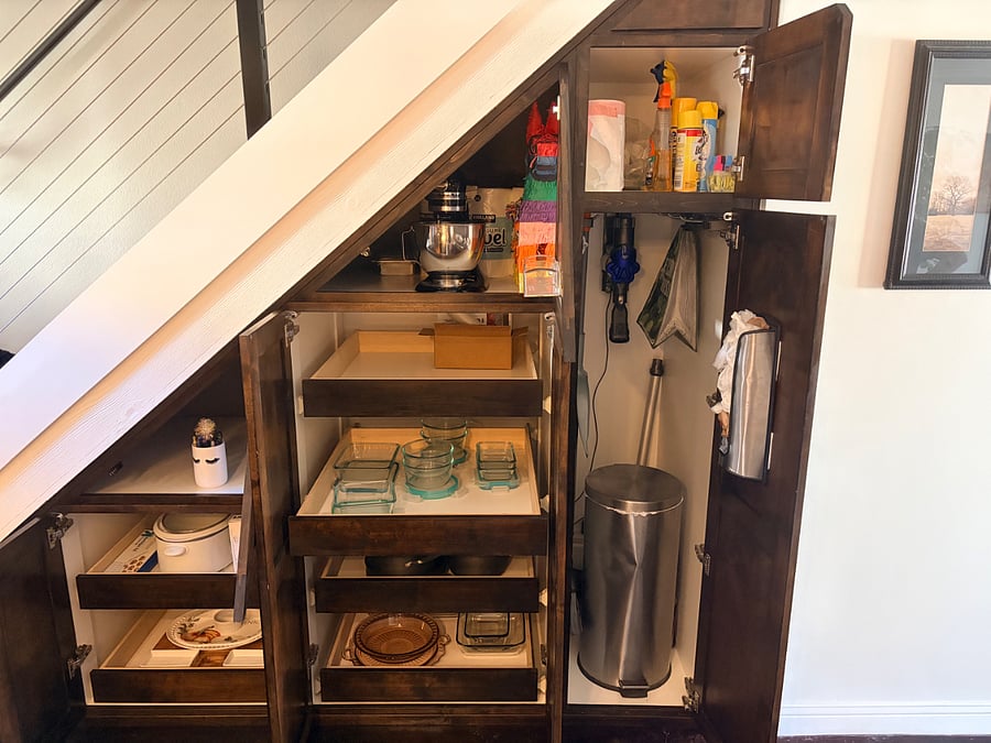 Under stair storage, cleaning items, extra paper towel, recycle bin, pinata. 