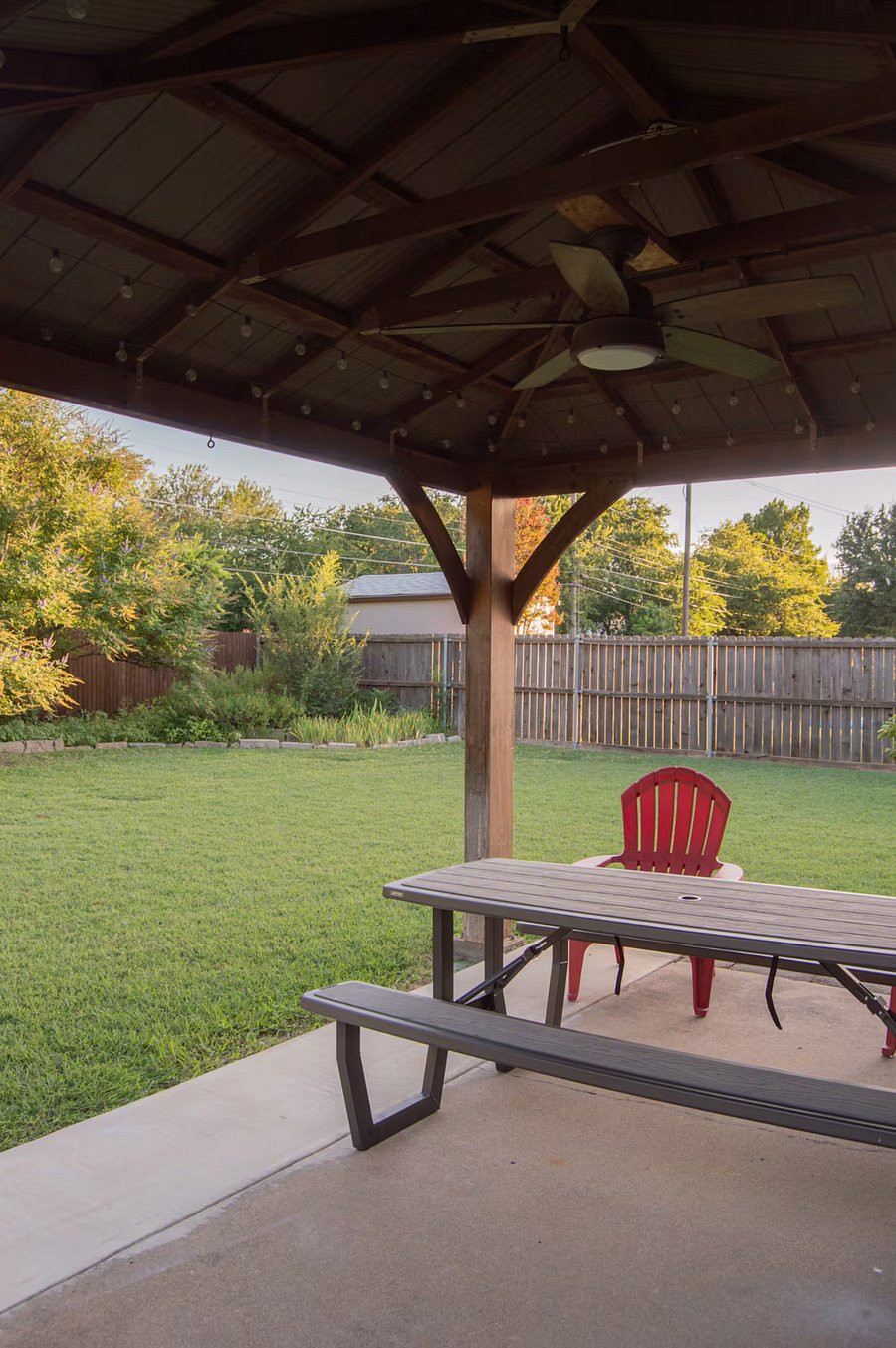 This covered patio includes seating, outdoor fan and patio lights.