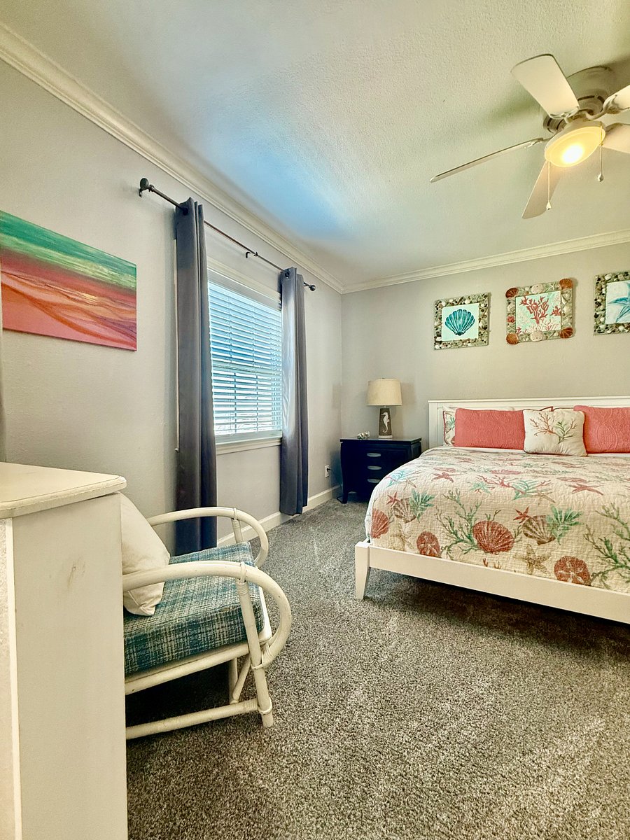 King bedroom with window looking out to beach