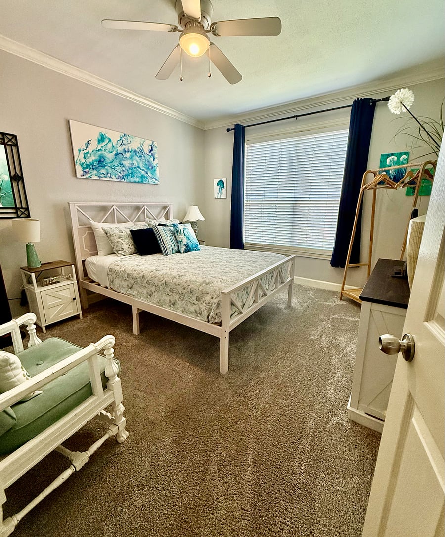 3rd bedroom with windo looking out to green area and swimming pool