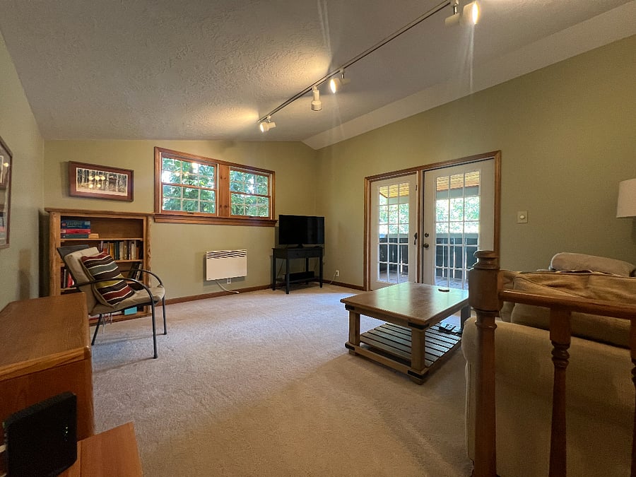 Upstairs Living room with TV and French doors out to upstairs balcony