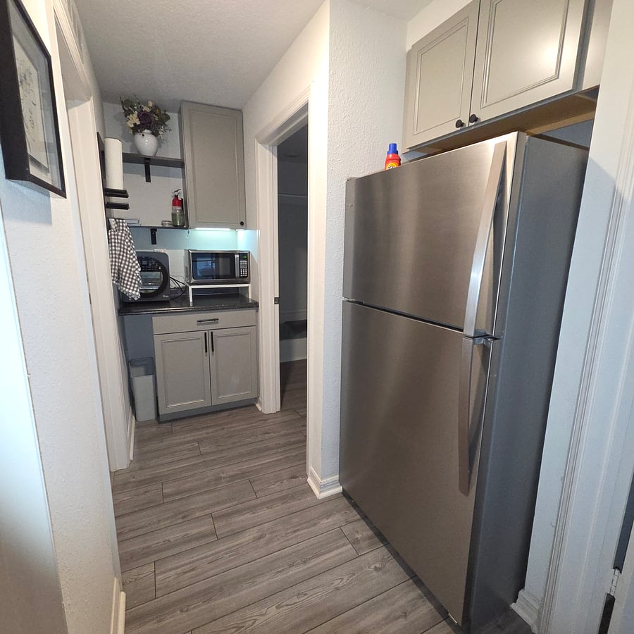 Galley kitchen with all the kitchen utensils/ convenience for l8ght meal prep. Full-size fridge