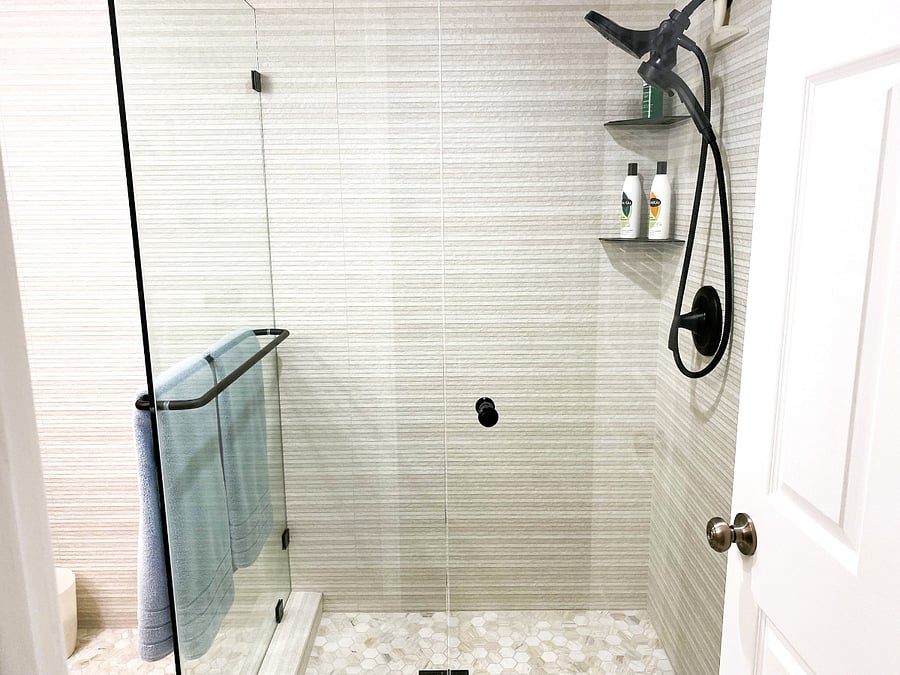 New porcelain tile shower with black two head shower fixture