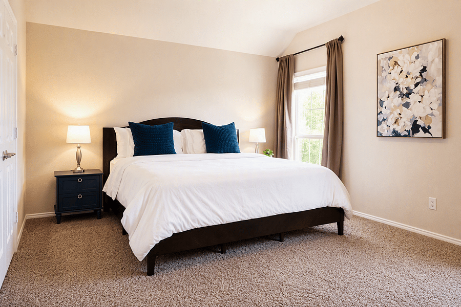 King bed with hotel-quality linens and blackout curtains.