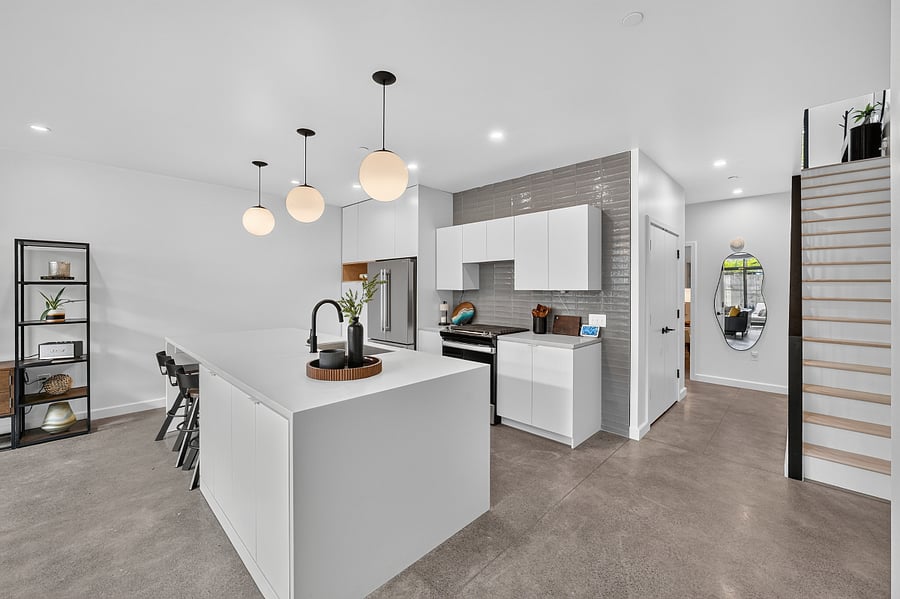 Kitchen area with view of doors to laundry area and stair way to second level.