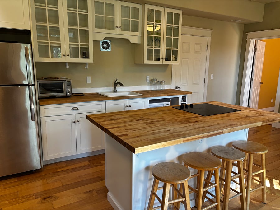 Well appointed kitchen with microwave, counter oven, full size stainless steel fridge and stoneware dishes. Waffle maker, caphalon pots and pans