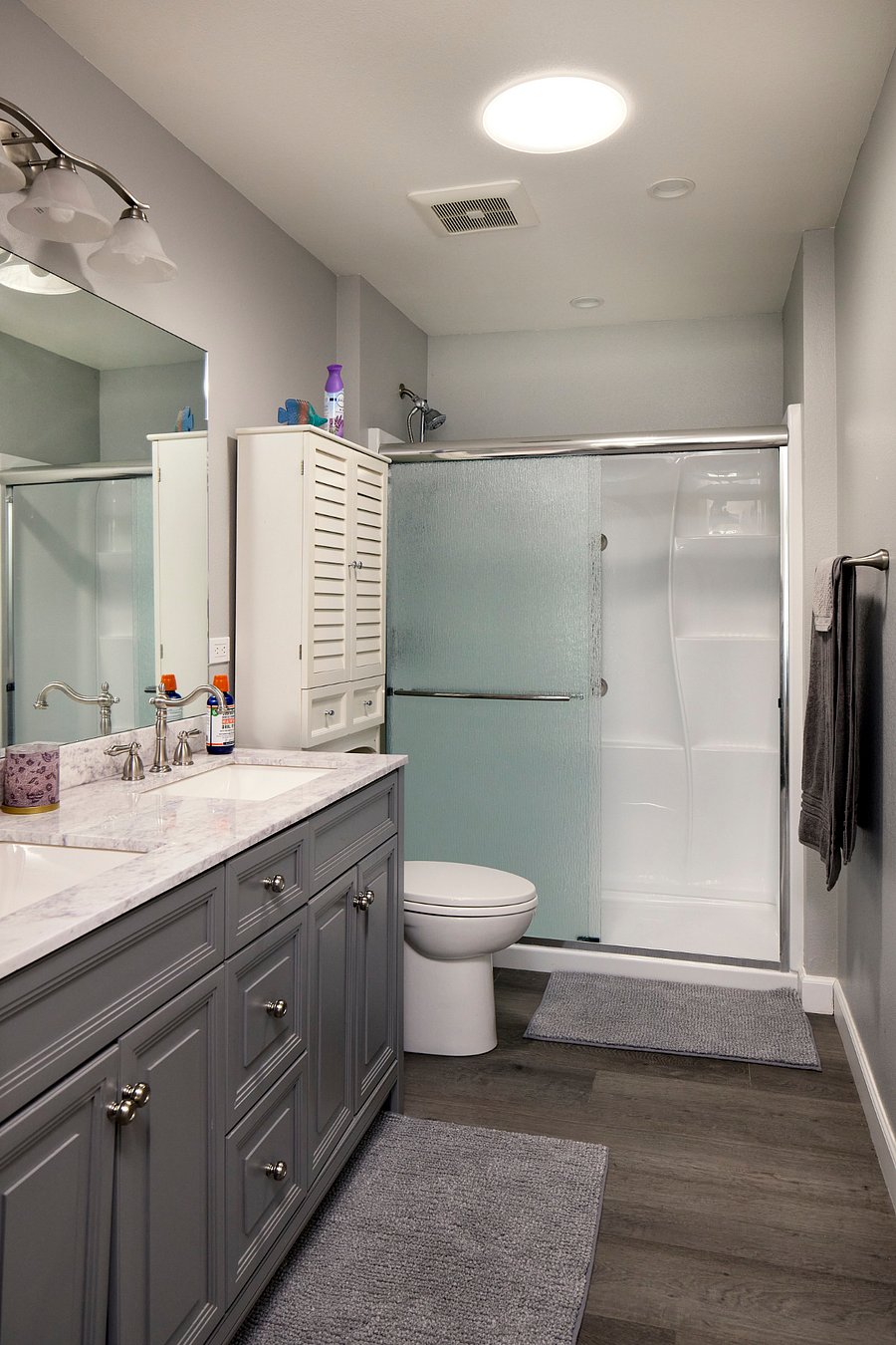 En-suite bathroom with double sinks and glass shower.