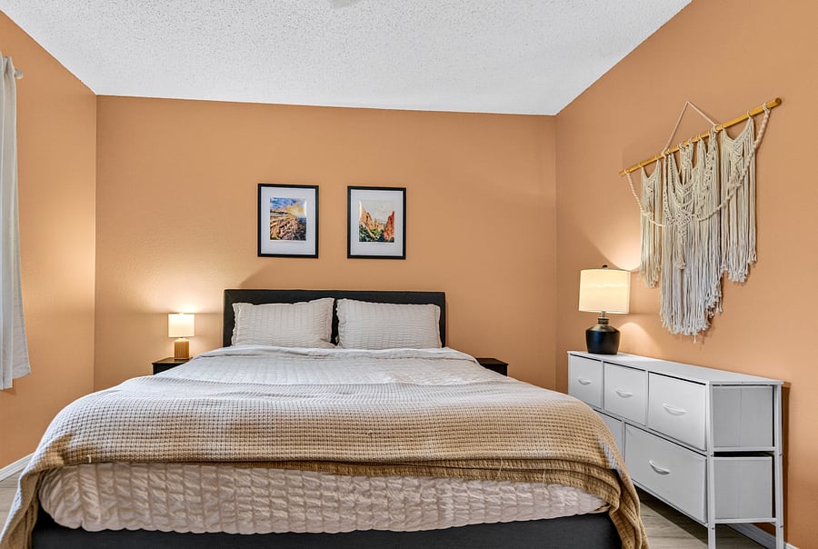 Secondary bedroom featuring dedicated workspace, room darkening shades, and plentiful closet space for guest use.