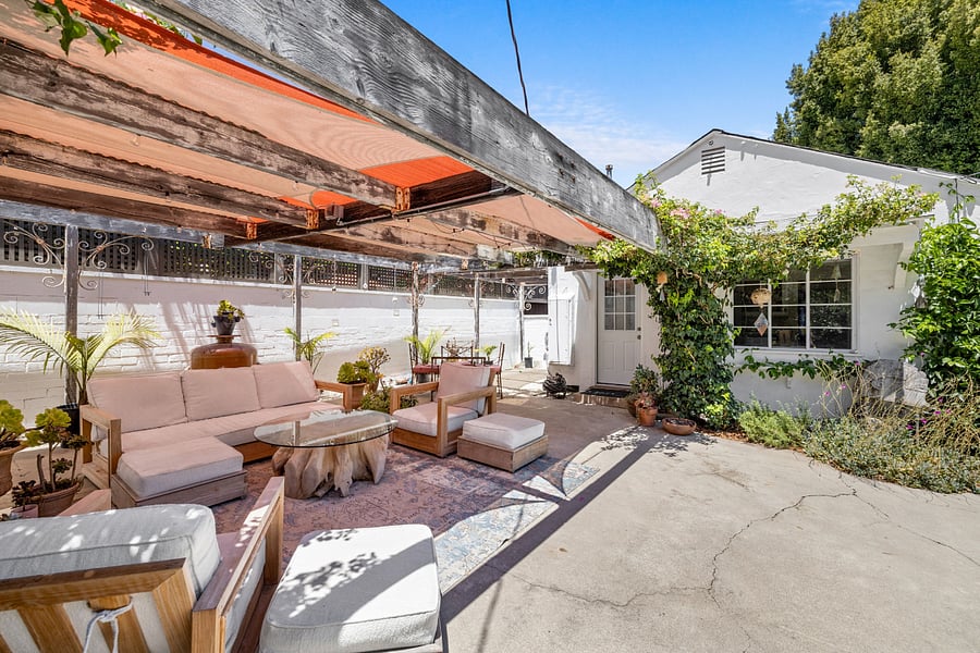 Outdoor living space in fully enclosed garden with fruit trees and shade.