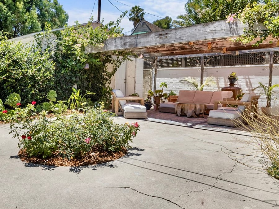 Outdoor living space in fully enclosed garden with fruit trees and shade.