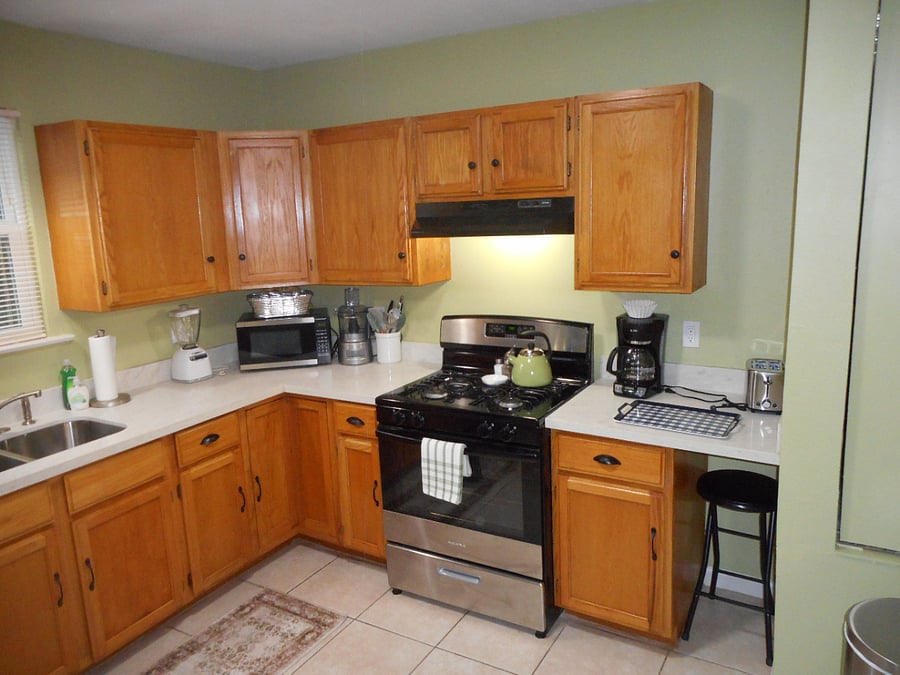 Kitchen features granite countertop, full sized stove and generous cabinet storage space.