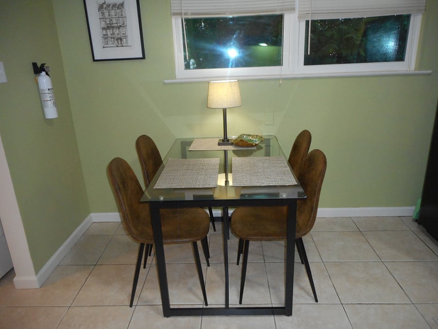 Sparkling glass top dining table with leather chairs. 