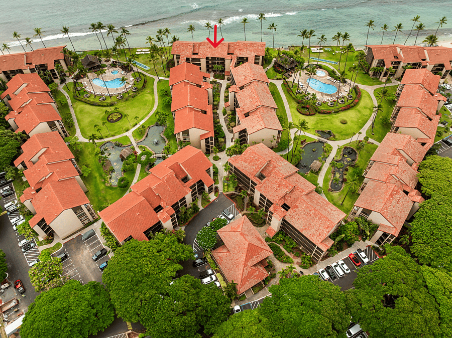 Aerial view from the entrance side of Papakea Resort. Our condo is marked by the red arrow and is conveniently located between both pool, hot tub, and BBQ areas.