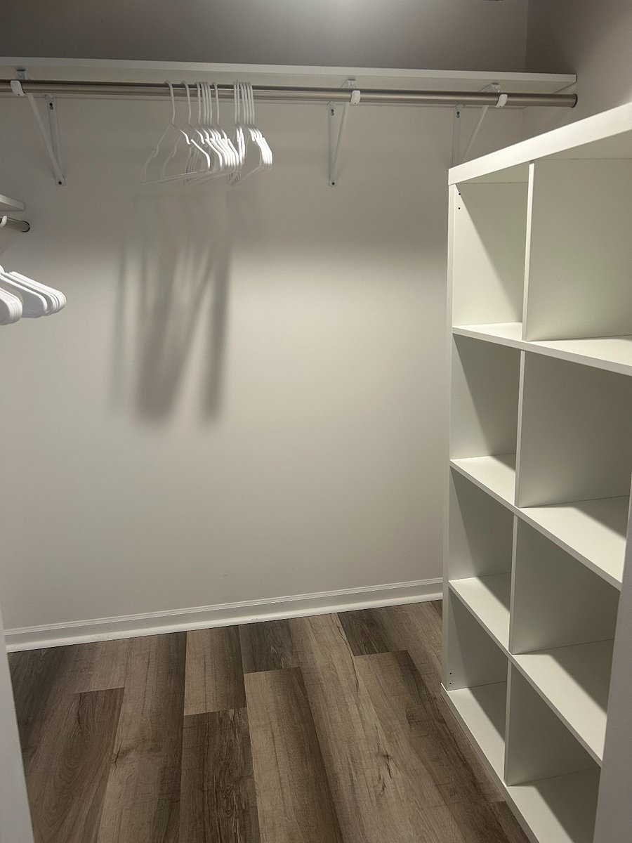 Large walk-in closet with dual hanging rods and storage cubes in basement bedroom