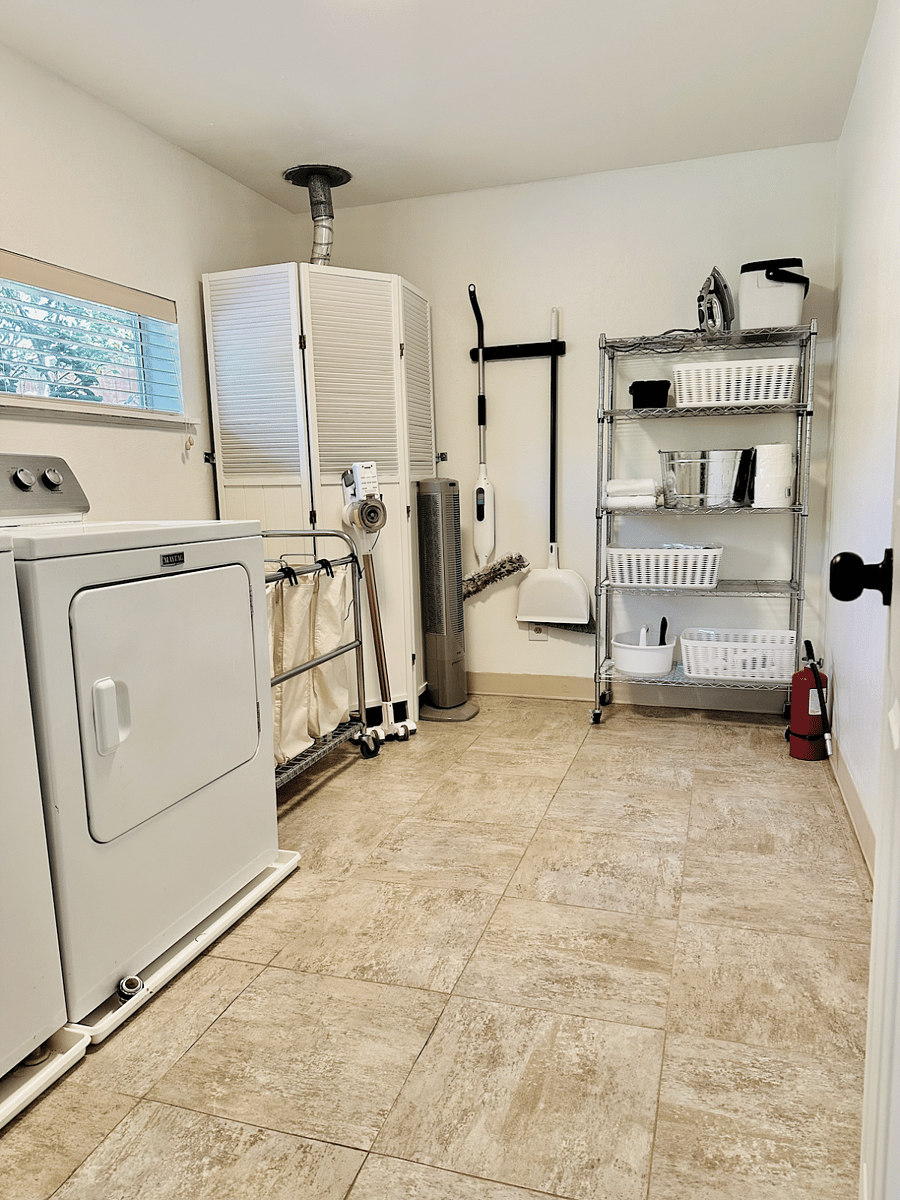 Large laundry room with a full washer and dryer and ironing board