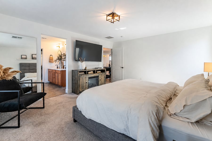 Primary Suite with smart TV, electric fireplace, full length mirror and sitting area.