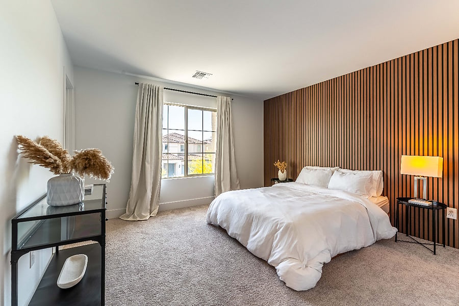 Bright upstairs bedroom with a statement accent wall and walk-in closet.