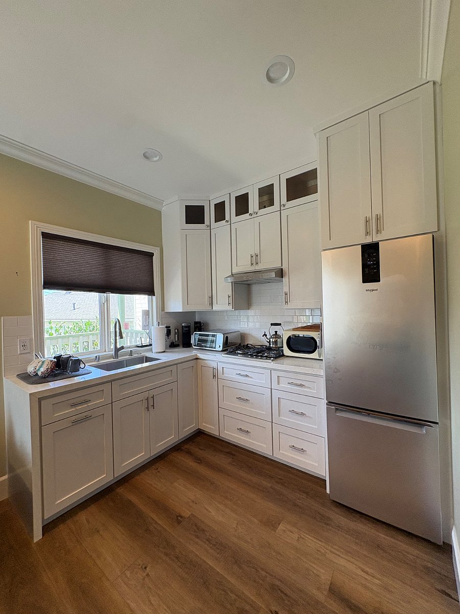 Kitchen with custom cabinets, ninja air fryer, stove, microwave, coffee maker and full size refrigerator