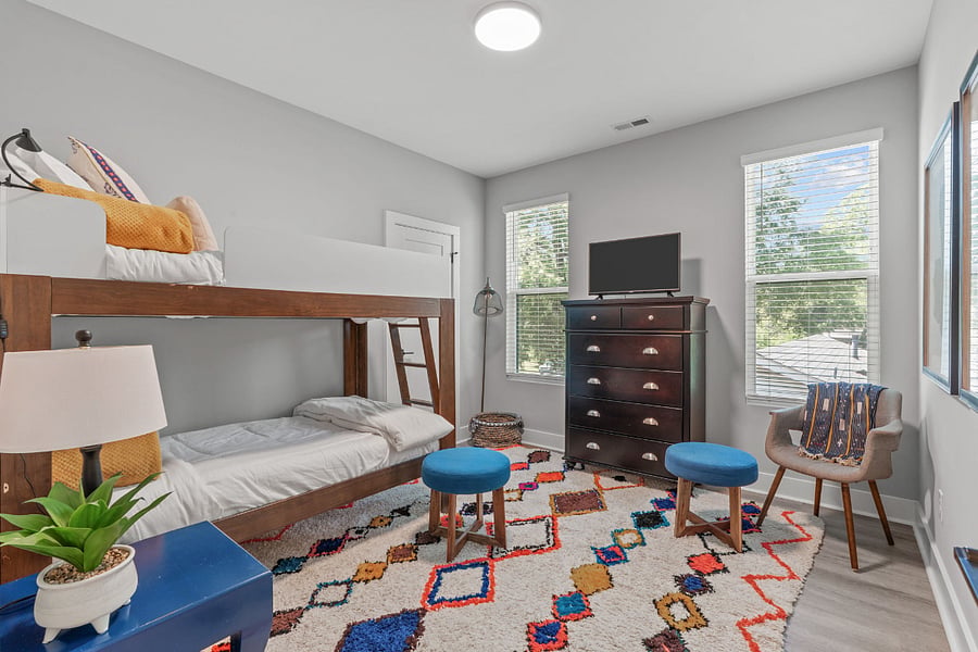 Bunk Room features a SmartTV, reading light, walk in closet that offer luggage racks, additional shelving, hangers and one tower fan. Blackout curtains have been added to bedroom windows but not shown in photos.
