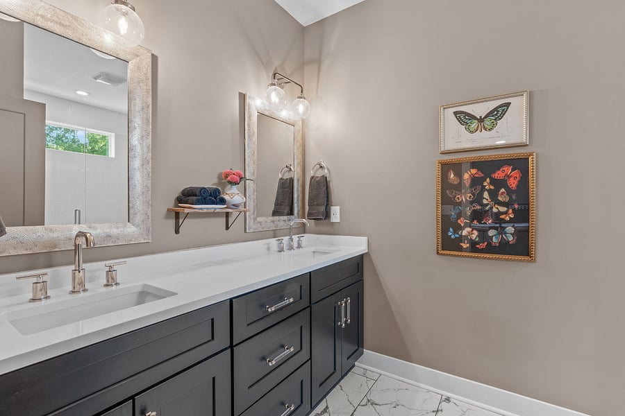 Primary ensuite offers dual vanities with quartz countertops.