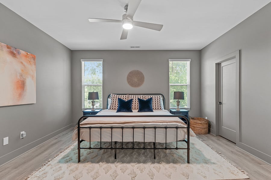 Primary king bedroom features two separate walk in closets offering luggage racks, additional shelving, hangers and one tower fan. Blackout curtains have been added to bedroom windows but not shown in photos.