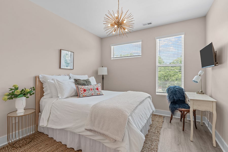 Queen bedroom features a SmartTV, a walk in closet offering a luggage rack, additional shelving, hangers and one tower fan. Blackout curtains have been added to bedroom windows but not shown in photos.