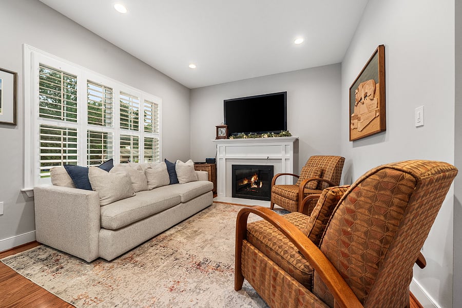The living room with a glass fireplace could flex as a home office.