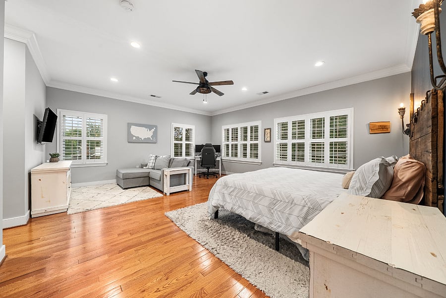 The oversized primary suite features a king-sized bed, cozy sitting area, and desk.