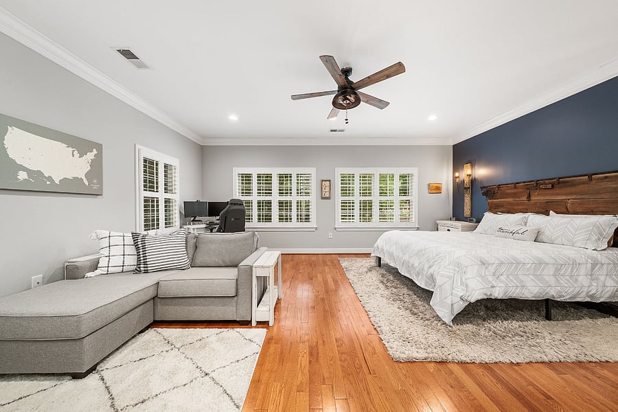 The oversized primary suite features a king-sized bed, cozy sitting area, and desk.