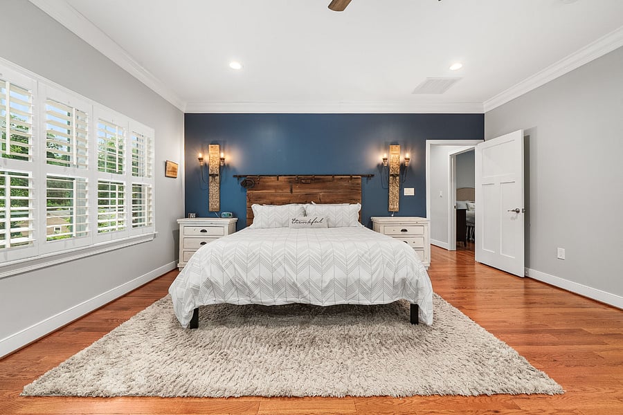 The oversized primary suite features a king-sized bed, cozy sitting area, and desk.