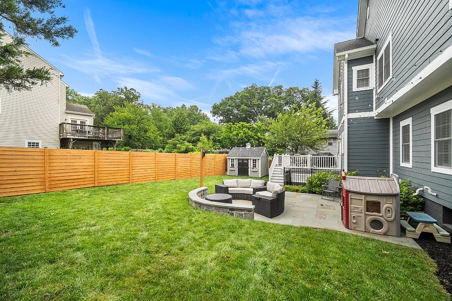 French doors off the kitchen open to a low-maintenance Trex deck overlooking a spectacular, fully reimagined backyard. Enclosed by a premium horizontal white cedar privacy fence, freshly stained in July 2026, the outdoor space features a gorgeous flagstone patio with a built-in sitting wall, tailored landscaping, and plenty of room for entertaining or relaxing outdoors.