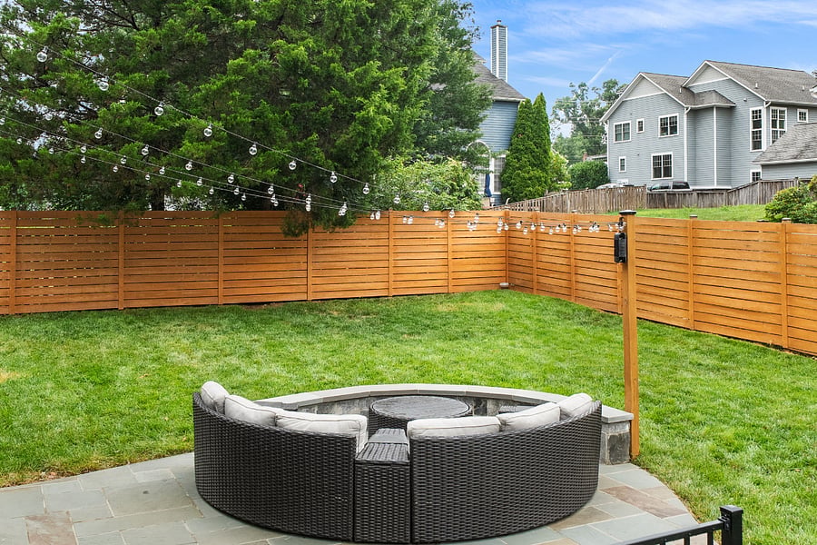 French doors off the kitchen open to a low-maintenance Trex deck overlooking a spectacular, fully reimagined backyard. Enclosed by a premium horizontal white cedar privacy fence, freshly stained in July 2026, the outdoor space features a gorgeous flagstone patio with a built-in sitting wall, tailored landscaping, and plenty of room for entertaining or relaxing outdoors.